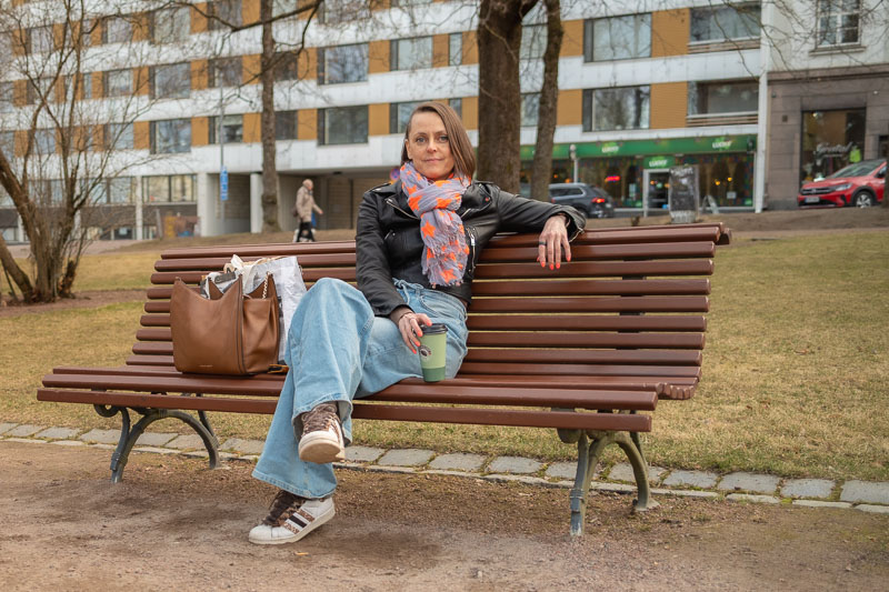 Tfcd nainen istuu puiston penkillä